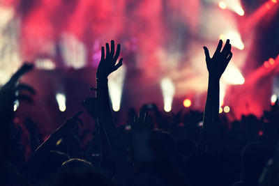 Close-up of silhouette hands against sky at night