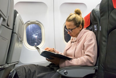 Woman using mobile phone while sitting in bus