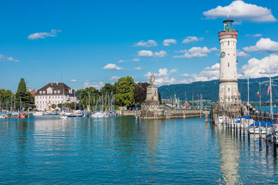 View of lighthouse by sea against buildings