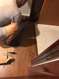 Low section of man working on hardwood floor at home