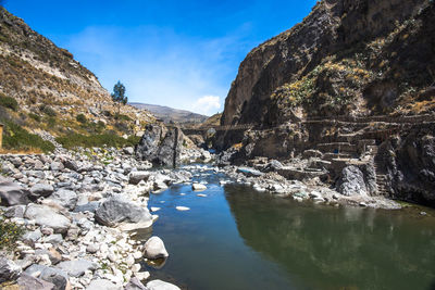 Scenic view of river amidst mountains against sky