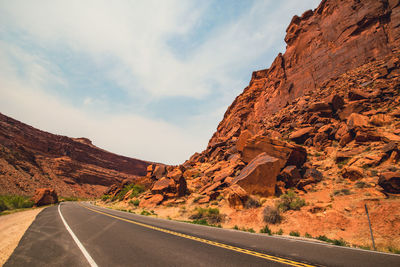 Road by rock formation against sky