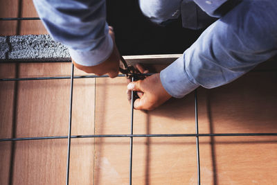 Low section of man working on wooden floor