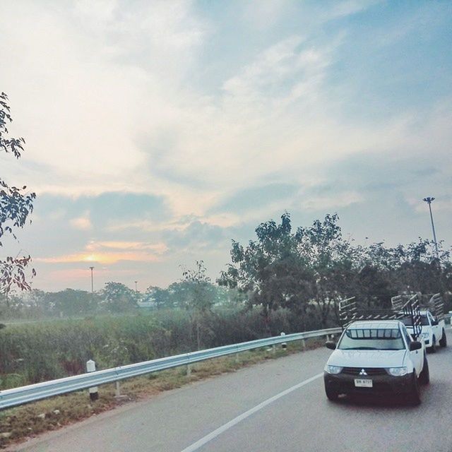 transportation, road, sky, tree, land vehicle, mode of transport, car, the way forward, road marking, cloud - sky, on the move, diminishing perspective, street, country road, cloudy, cloud, nature, travel, vanishing point, landscape