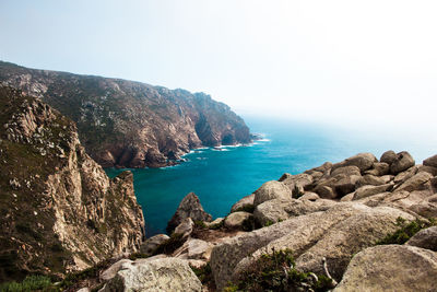 Scenic view of rocks in sea against clear sky