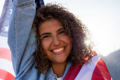 Slim beautiful woman holding usa flag celebrating independance us day. sunlight from back