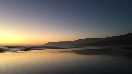 Scenic view of sea against clear sky during sunset