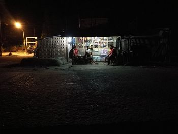 People in illuminated city at night