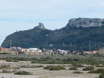 Scenic view of buildings and mountains against sky