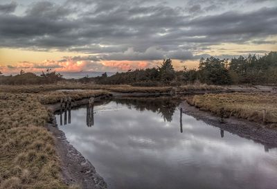 Scenic view of creek against sky during sunset