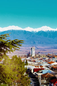 High angle view of townscape and mountains against blue sky