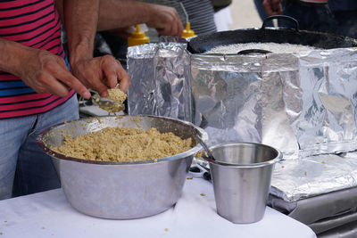 Midsection of man preparing falafel on stall at market