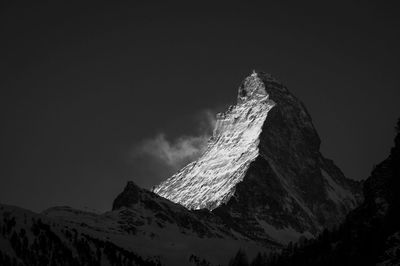 Scenic view of snowcapped mountains against sky at night