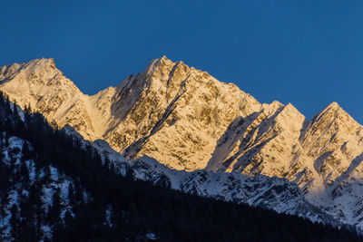 Scenic view of snowcapped mountains against clear blue sky