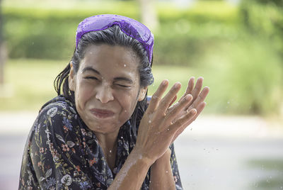 Portrait of smiling woman amidst splashing water