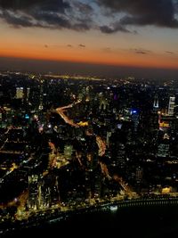 Aerial view of illuminated buildings against sky at night