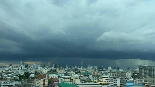 Panoramic view of buildings in city against storm clouds