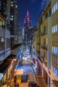 Illuminated city street amidst buildings at night