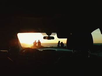 Silhouette people in car during sunset