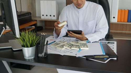 Midsection of man working on table