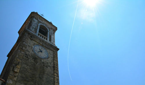 Low angle view of clock tower against blue sky