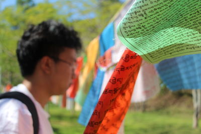 Close-up of prayer flags with man in background