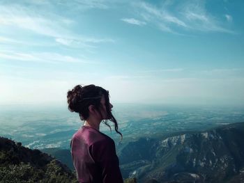 Woman looking at mountains against sky