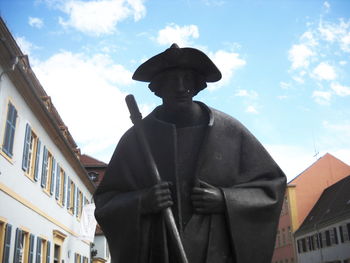 Low angle view of statue in city against sky