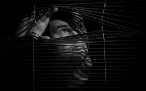 Low angle view of man looking through window