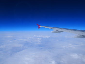 Airplane wing against cloudy sky