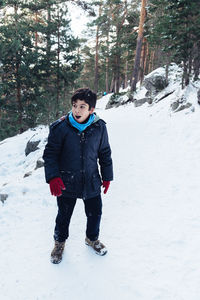 Full length of boy playing with snow in forest