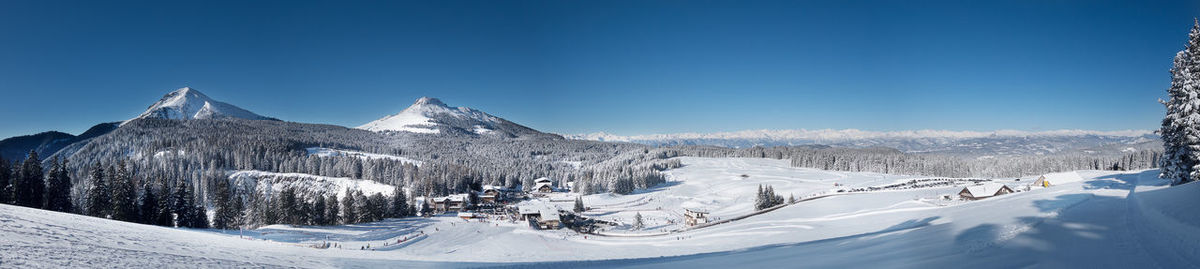 Panoramic view of snowcapped mountains against clear blue sky