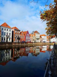 Reflection of buildings in river against sky in bruges