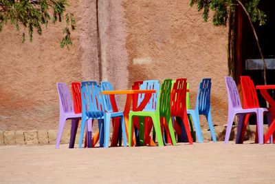 Multi colored chairs on table at beach