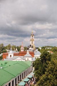 View of buildings in city against cloudy sky