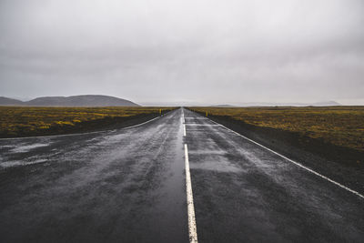 Empty road along countryside landscape