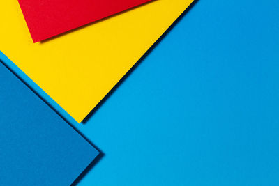 High angle view of yellow paper over blue background