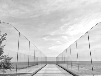 Bridge over empty street against sky