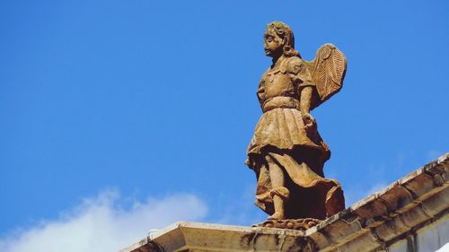 Low angle view of statue against blue sky
