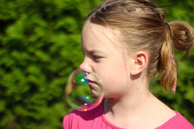 Bubble on face of cute girl in sunny day