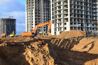 View of construction site by buildings against sky