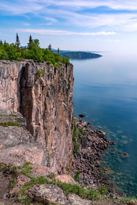 Rock formations by sea against sky