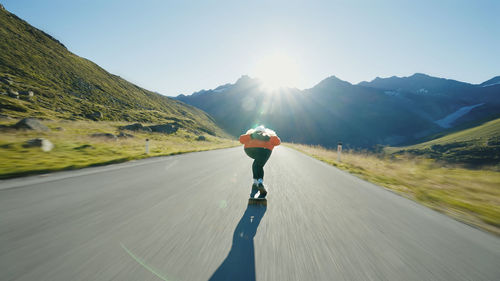 Rear view of man walking on road