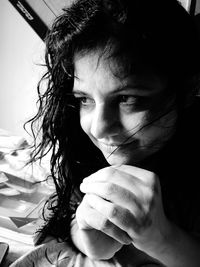 Close-up of thoughtful woman leaning on bed