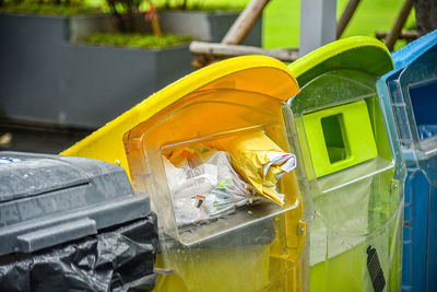 Close-up of yellow garbage bin in city
