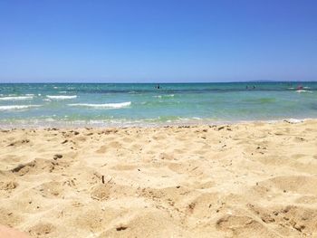 Scenic view of beach against clear blue sky