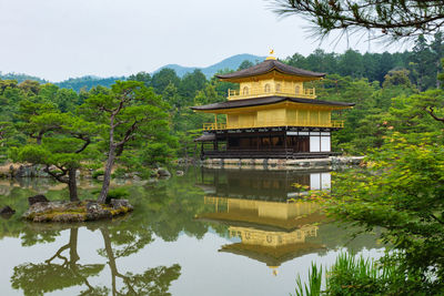 Building by lake against sky