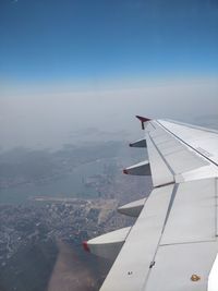 Airplane flying over landscape against sky