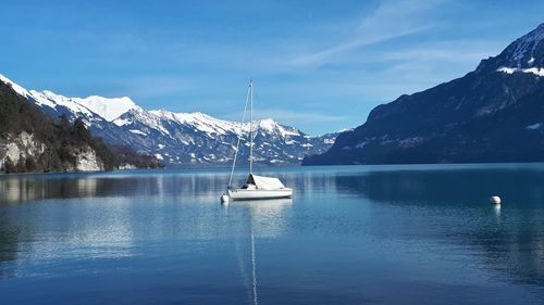 Scenic view of lake by snowcapped mountains against sky