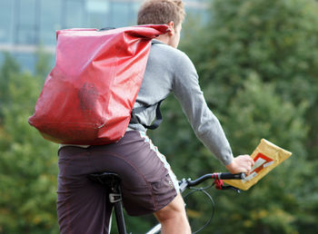 Male bike courier messenger on bicycle delivering a parcel 